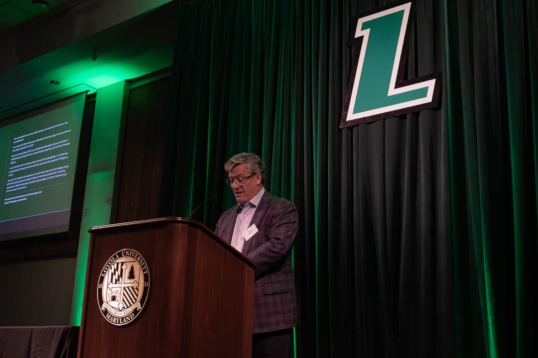 Tim Madey '84 at the podium giving the fundraising update