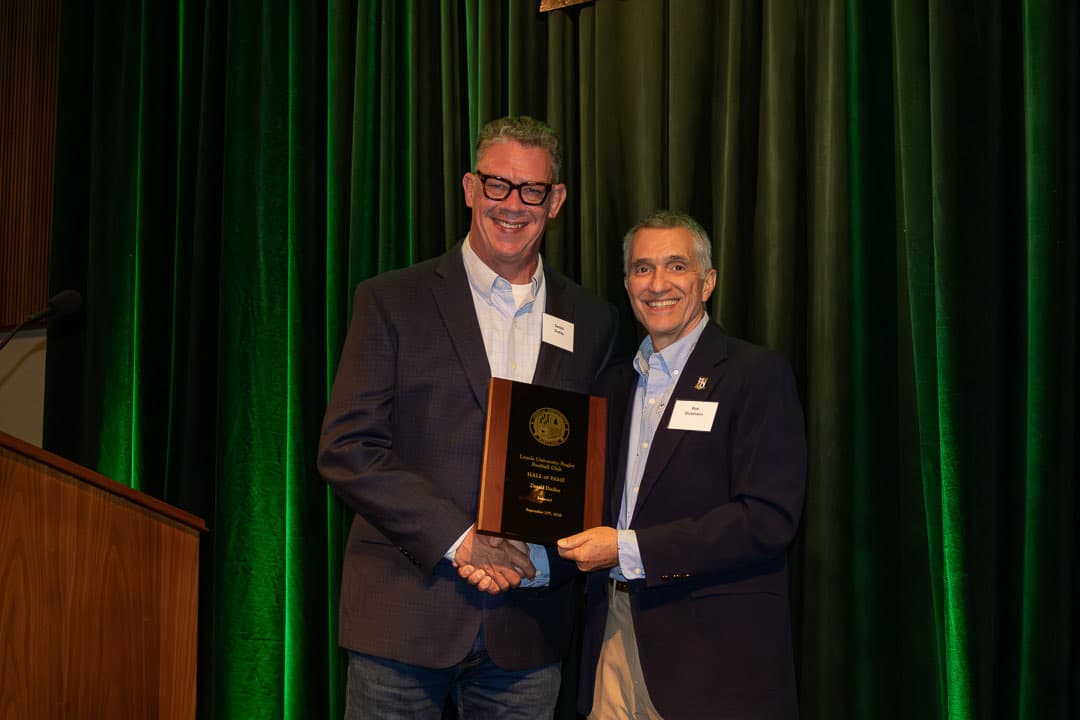 Derald Dudley receiving his Hall of Fame plaque from Rob Dickinson '86