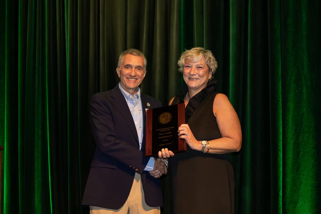 Maria Burkhardt accepting the Hall of Fame plaque for Greg Burkhardt '90, inducted in memoriam